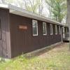 A rectangular brown building featuring a sign that says "Birch Lodge" and a wheelchair ramp at the front and side entrances.