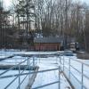 The path to a dock in winter and a wooden boat house.