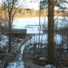 A wooden stairway leading down to a boat house and dock in winter.