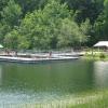 Lifeguards stand on a large wooden dock lined with metal railings and a small pool in the center.