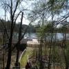 A wooden stairway leads down to a boat house and wooden dock in spring.