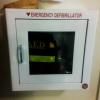 An emergency defibrillator in a sealed box on the wall in Maple Lodge 