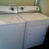 White top-loading washing machine and side-loading dryer in Maple Lodge.