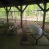 Screened-in Red Pine Pavilion exterior with picnic benches and concrete flooring.