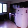 Tamarack Lodge kitchen, including a refrigerator, stove, sink, trashcan, and counter space.