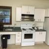 White Pine Lodge kitchen, including a refrigerator, stove, sink, trash can, microwave, and counter space.