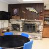 White Pine lodge common area, with a television, fireplace, and bookshelf in the background and a table and chairs in the foreground.