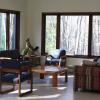 A White Pine Lodge common area with large windows, several chairs, a couch, and a stuffed fox.