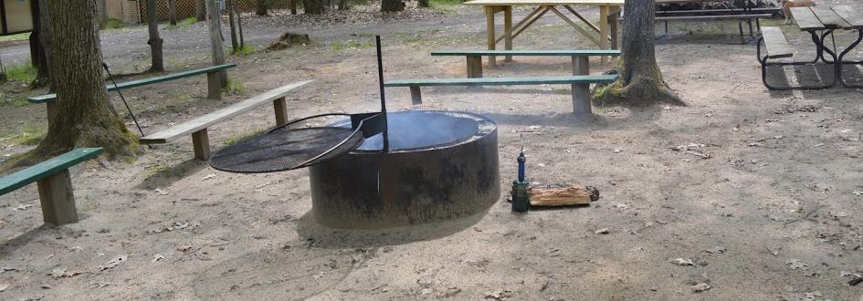 A circular fire pit surrounded by several long benches.