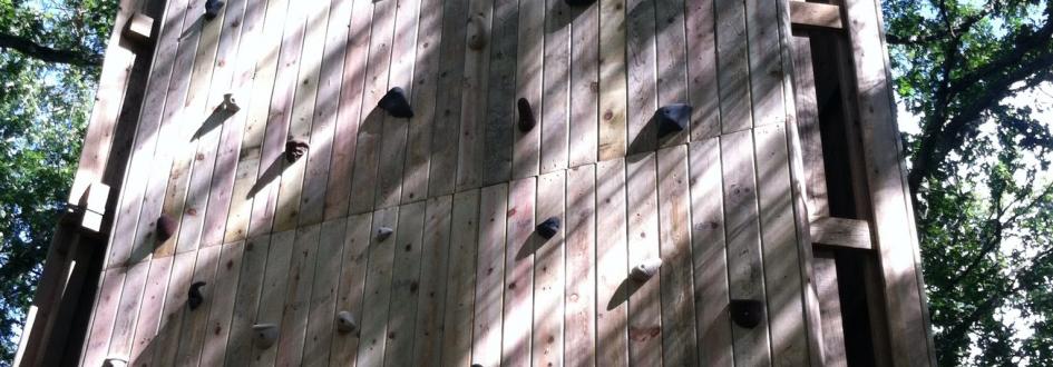 A large wooden climbing tower featuring several footholds.