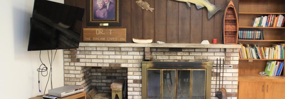 White Pine lodge common area, with a television, fireplace, and bookshelf.