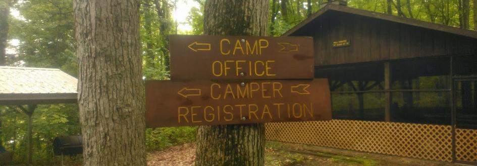 Signs that say "Camp Office" and "Camper Registration" pointing to the left.
